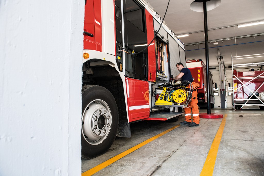 Firefighter with fire truck equipment; all logos removed. Slovenia, Europe. Nikon.