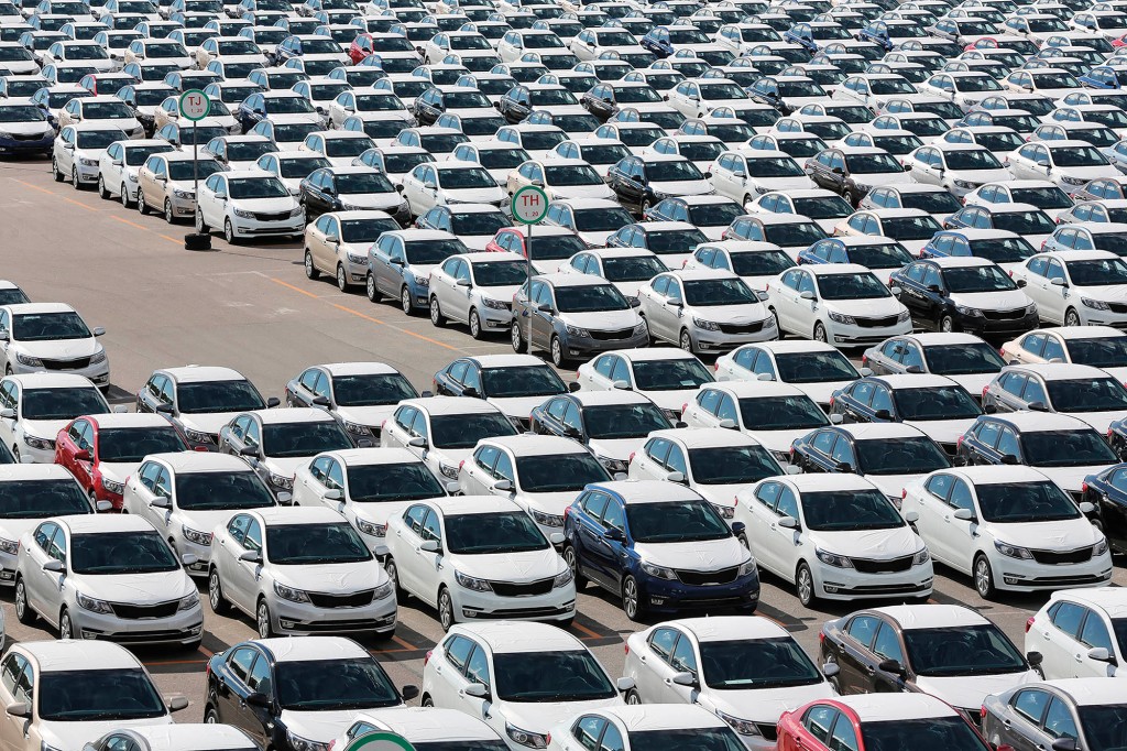 Completed Kia Rio vehicles sit with body panels covered in protective wrapping ahead of distribution in a parking lot outside the Hyundai Motors Corp. automobile plant in St Petersburg, Russia, on Friday, Aug. 14, 2015. By volume, Hyundai Kia is the largest automaker in Russia, holding that position as its 15% decline in unit year-to-date sales is the third best performance of all automakers selling in Russia. Photographer: Andrey Rudakov/Bloomberg